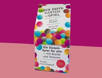 Kartenspiel Six Dots mit farbigen Punkten auf dem Karton, Hintergrund ist oben bordauxrot, unten altrosa