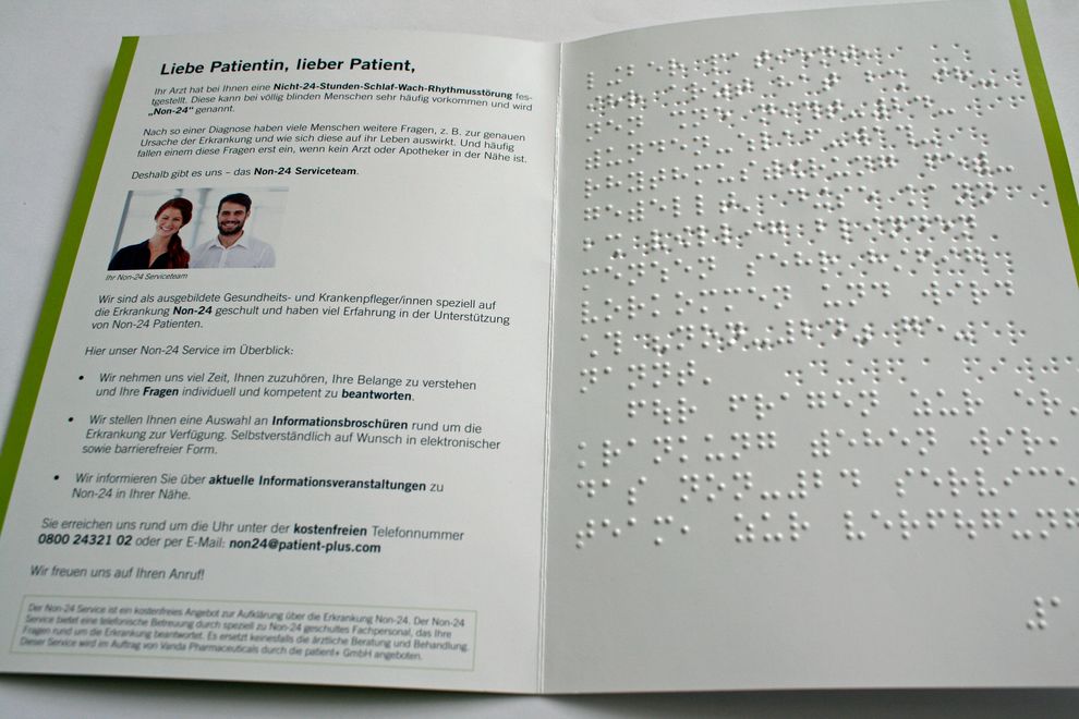 Aufgeschlagener Flyer mit Brailleprägung