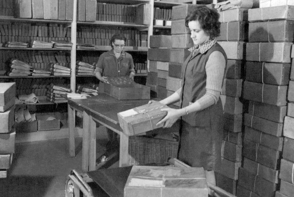 Historisches Foto: Zwei Frauen vor Regalen mit Kartons verpacken Bücher in Kartons - Aktivierung öffnet Bildergalerie in größerer Ansicht