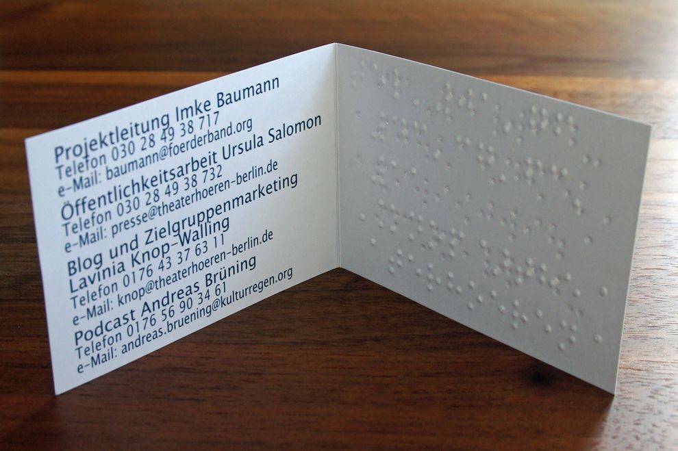 stehende aufgeklappte Visitenkarte mit Brailleprägung und Schwarzdruck