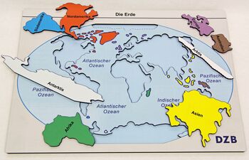 Kunststoffplatte mit Kontinenten als Puzzle-Teile, einige liegen außerhalb der Platte