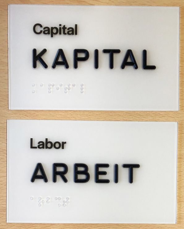 Zwei Schilder "Capital/Kapital" und "Labor/Arbeit"