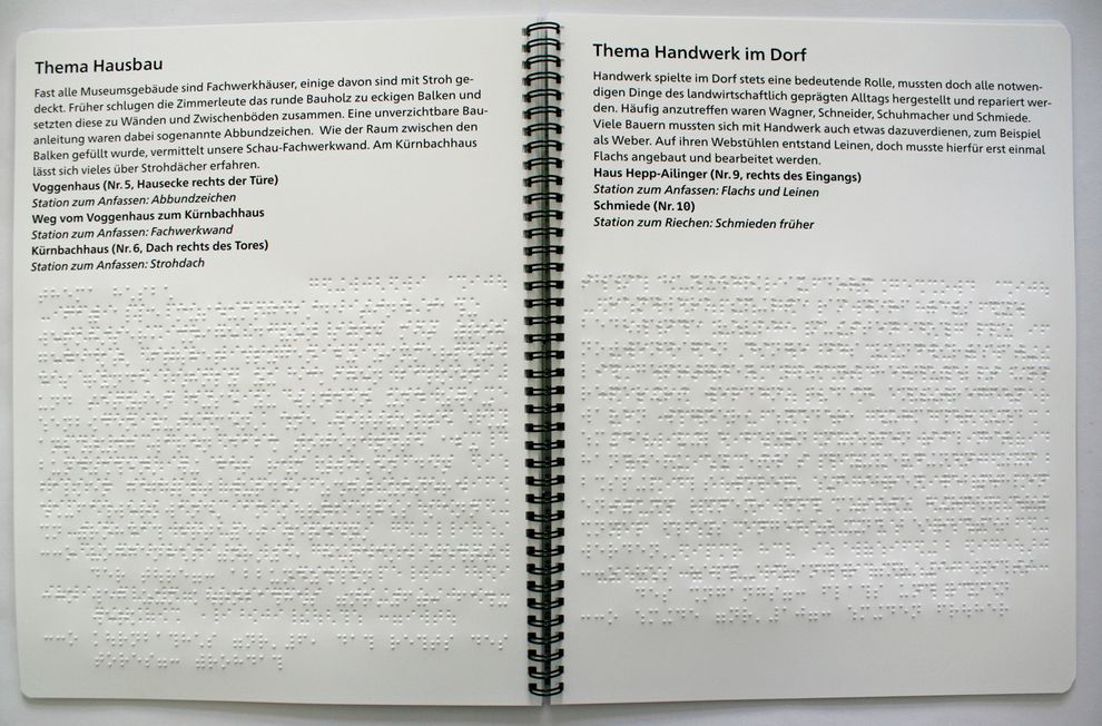 aufgeschlagene Broschüre mit Braille- und Großdrucktext (Thema: Hausbau und Handwerk)